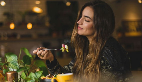 woman holding fork in front table